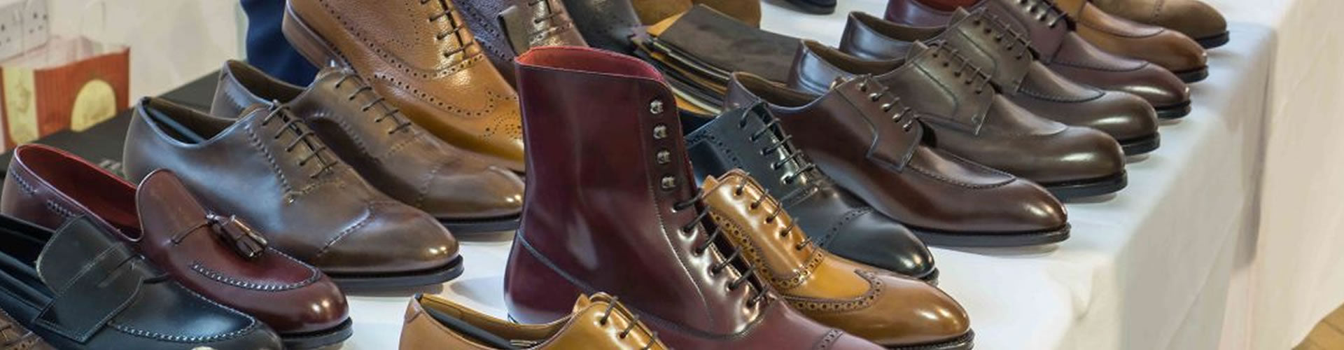 Close-up of stylish, polished leather shoes and boots, evoking luxury and craftsmanship at a shoe-shining event.