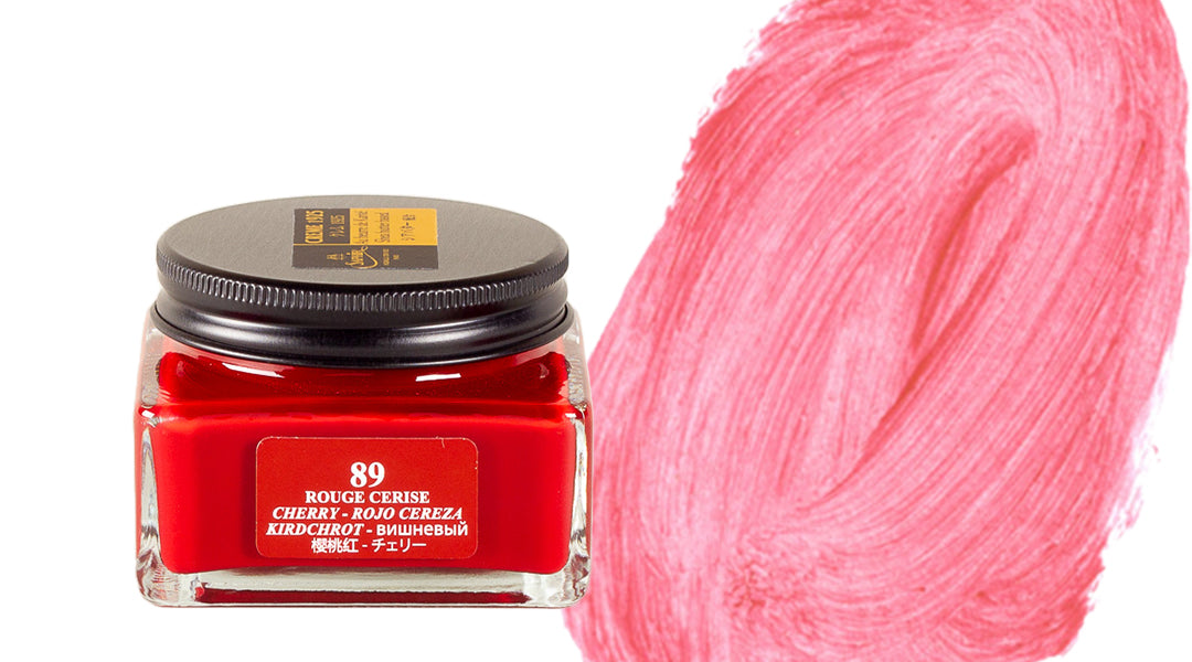 A square glass jar of cherry red paint labeled 89 Rouge Cerise sits next to a large, textured swatch of the same vibrant red color on a white background.