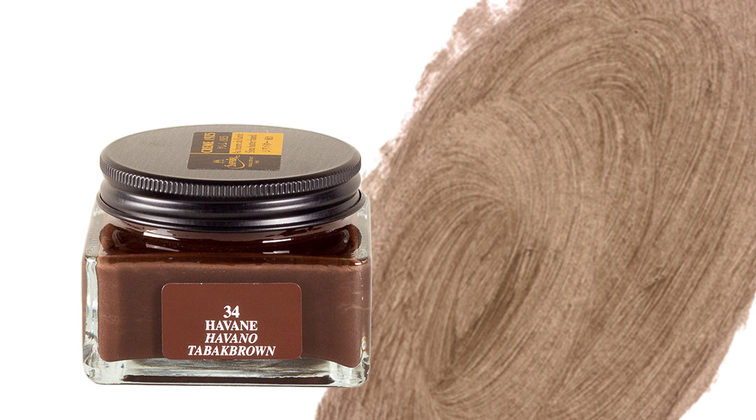 A glass jar of brown ink labeled 34 Havane Tabakbrown with the lid on, next to a broad, textured brown brushstroke on a white background.